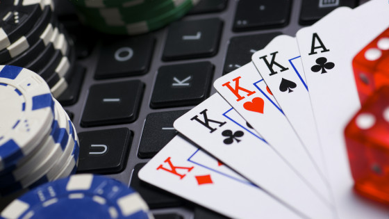 Playing cards, poker chips, and dice on a computer keyboard.